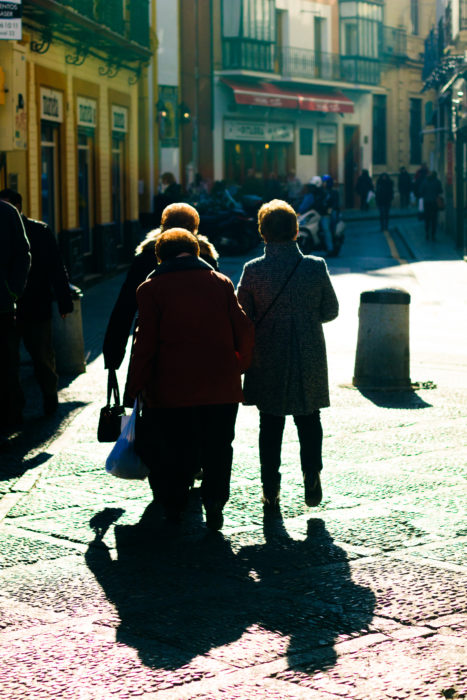 Three older woman walk in the streets.