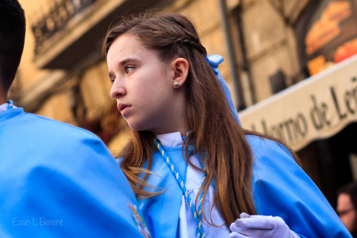 A girl looks to the side while marching in a Semana Santa procession